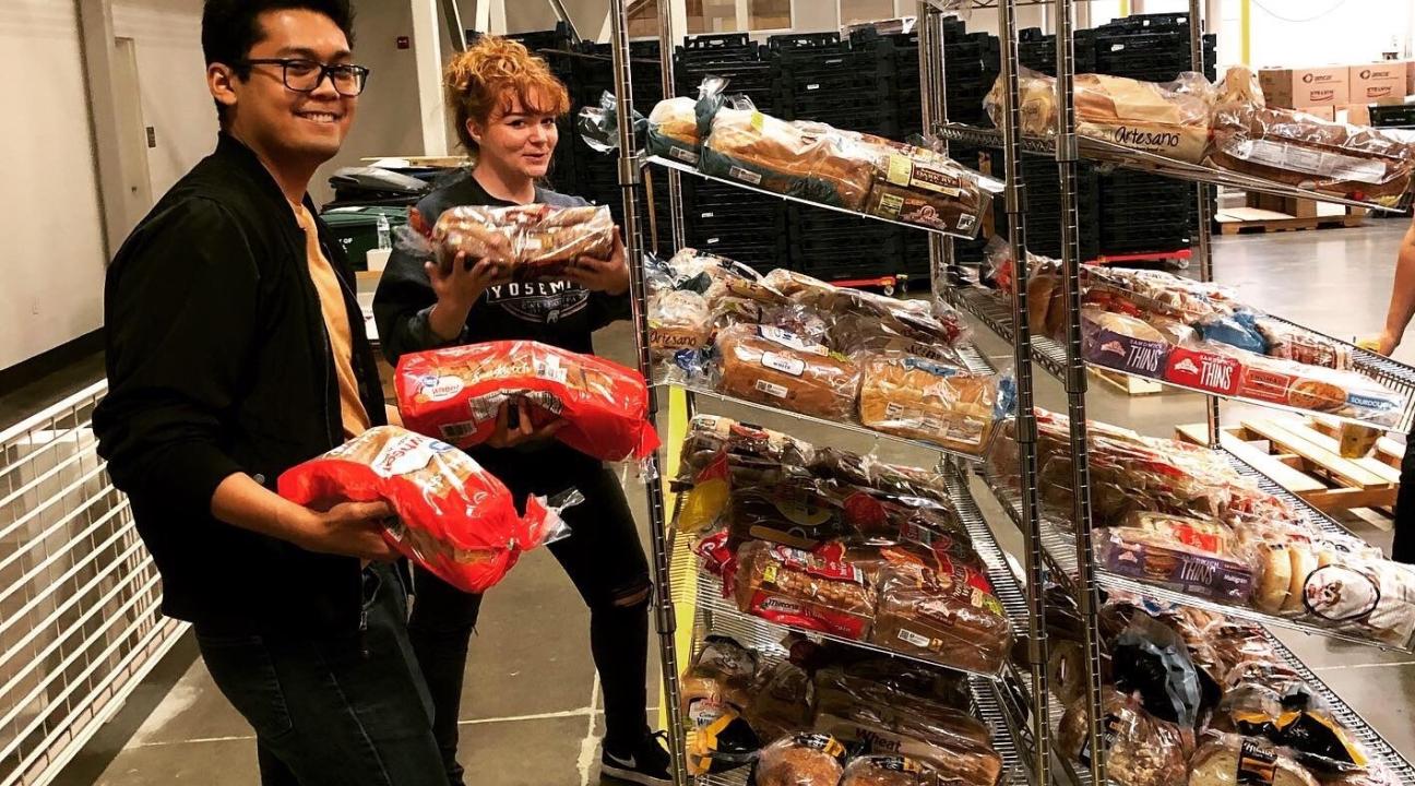 Two SHAC members smiling while holding bread
