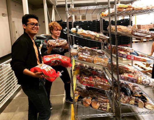 Two SHAC members smiling while holding bread